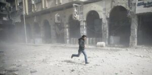 man is seen running after an air raid in the besieged town of Douma in eastern Ghouta in Damascus, Syria, February 6, 2018 PHOTO: REUTERS